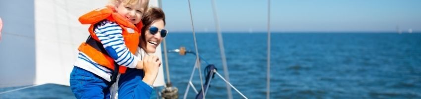 A picture of happy mother holding her daughter while sailing in ocean