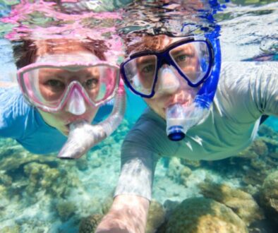 A couple is trying to snorkel with glasses.