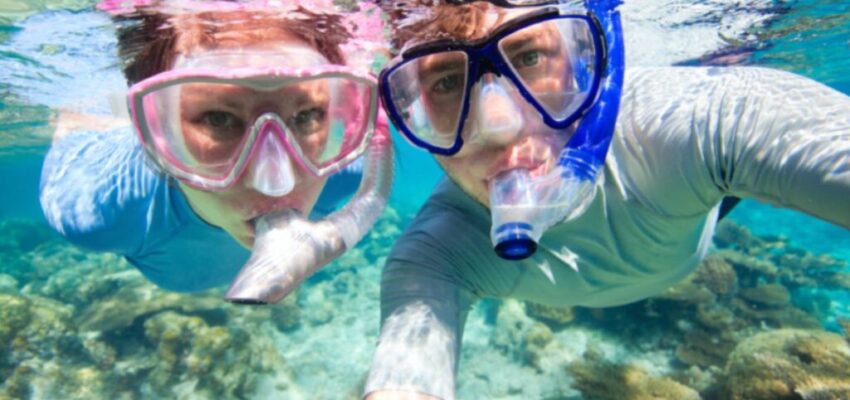 A couple is trying to snorkel with glasses.