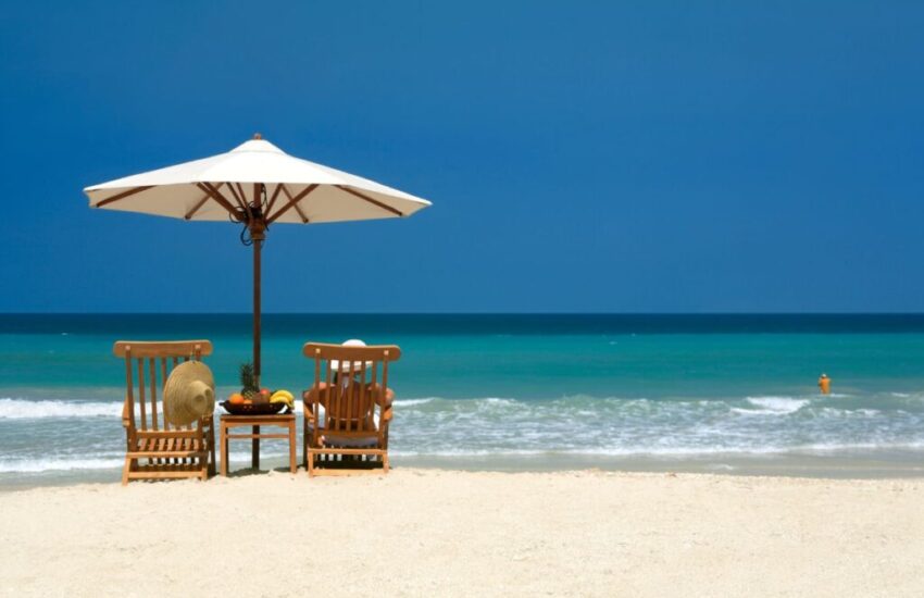 A person feels relaxed while sitting near the beach.