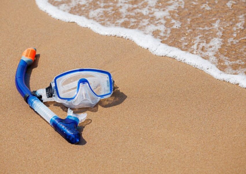 A snorkeling gear in the sand of the seashore.