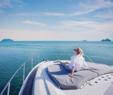 A lady on a yacht enjoying the yachting benefits.