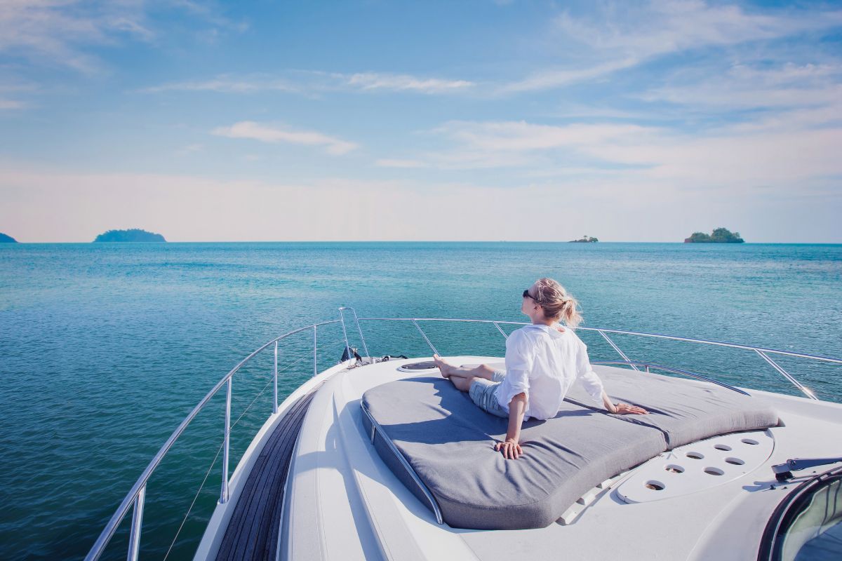A lady on a yacht enjoying the yachting benefits.